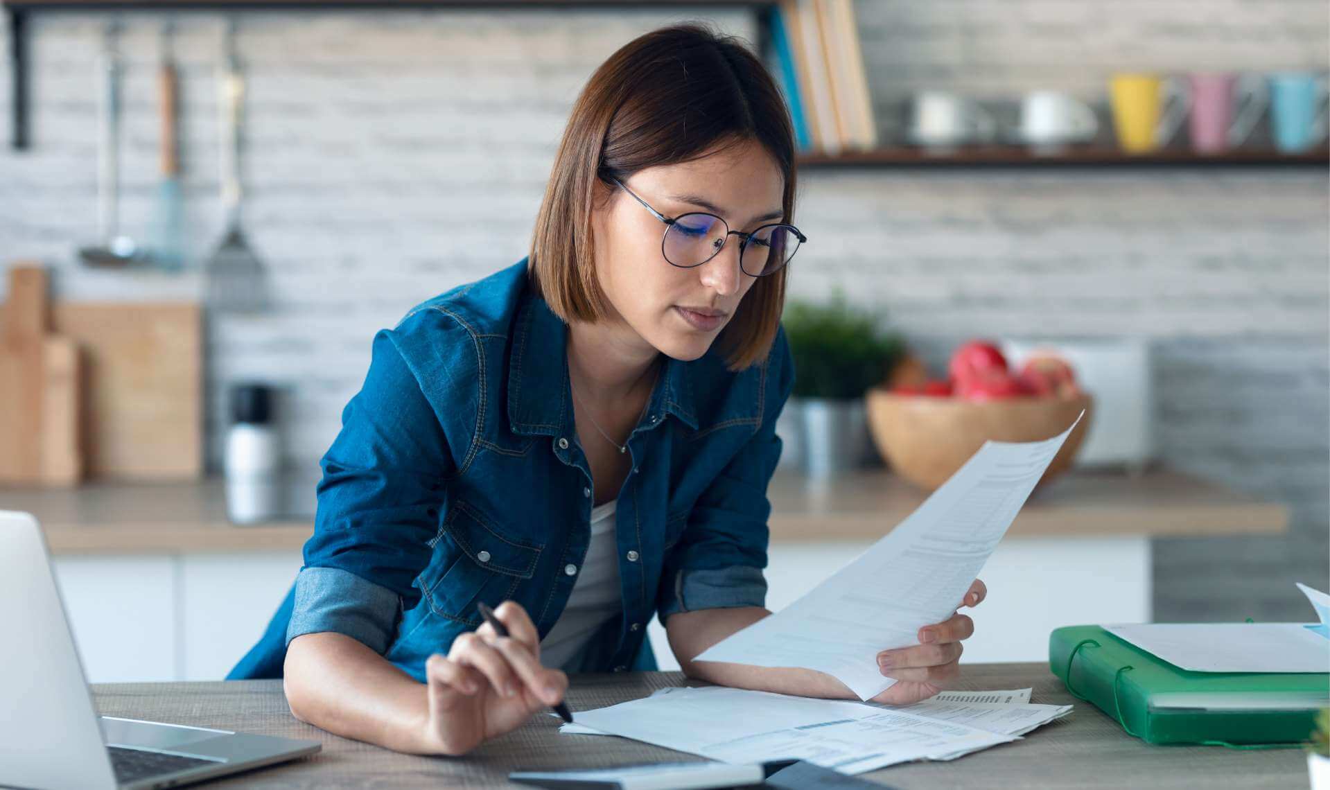 Woman reading white paper on a desk